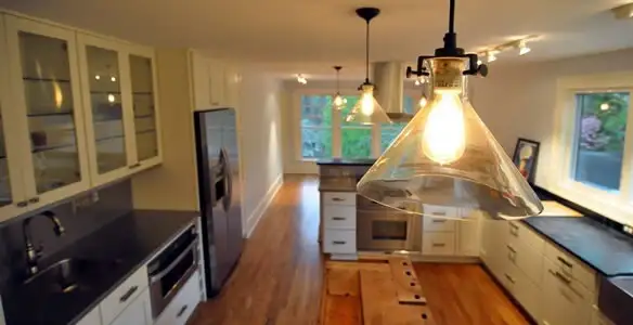 Residential electrician installing modern indoor light fixture in a home in Reno, NV