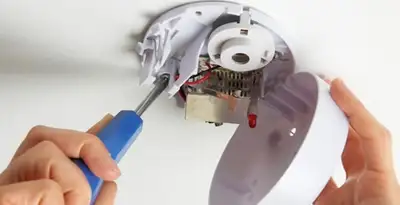 Certified technician wiring smoke detector during installation in Reno, NV